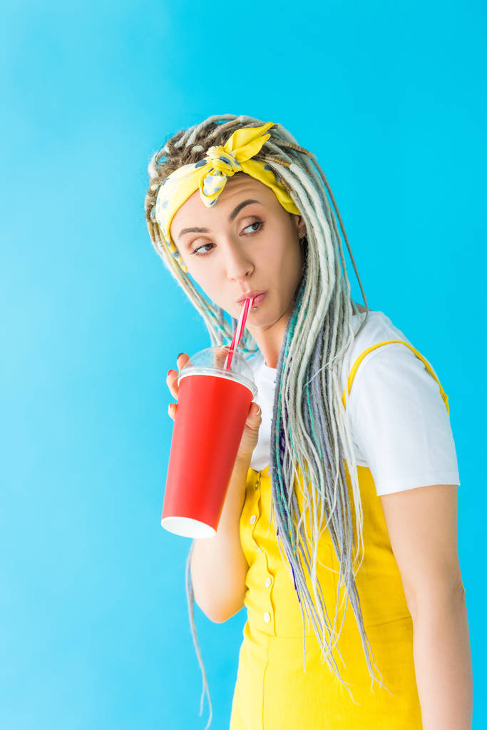 beautiful girl with dreadlocks drinking soda isolated on turquoise - Photo, Image