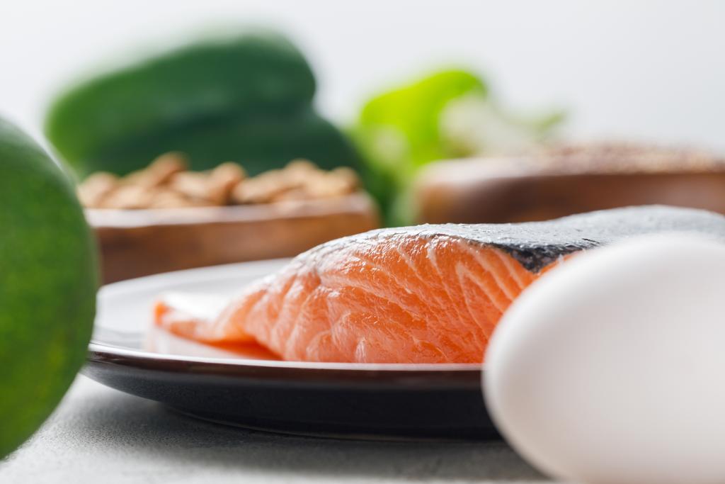 selective focus of fresh raw salmon on white plate, ketogenic diet menu - Photo, Image