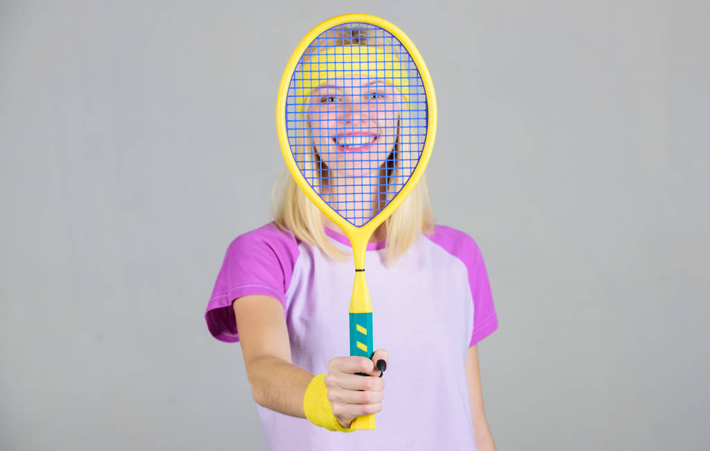 女性はテニスラケットを手に持つ。テニスクラブのコンセプト。テニススポーツとエンターテイメント。アクティブなレジャーと趣味。女の子フィットスリムブロンドはテニスをプレイ。健康を維持するためのスポーツ。アクティブなライフスタイル - 写真・画像