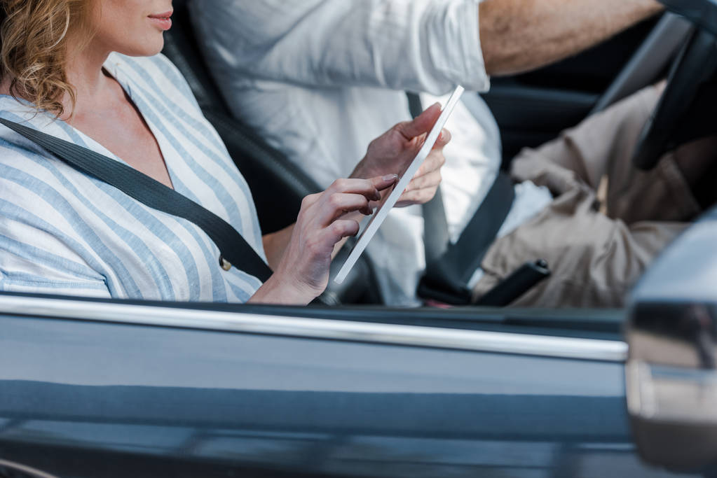 przycięte widok kobiety za pomocą cyfrowego tabletu w pobliżu kierowcy w samochodzie  - Zdjęcie, obraz