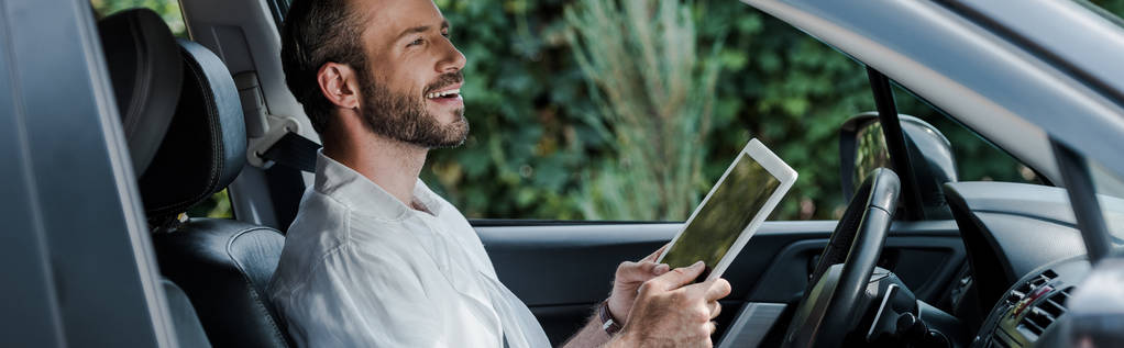 plan panoramique de l'homme heureux tenant tablette numérique dans la voiture
  - Photo, image