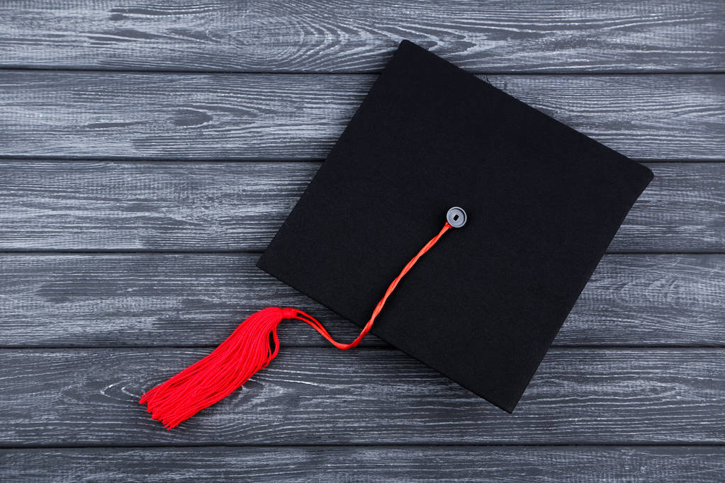 Capa de graduação na mesa de madeira preta
 - Foto, Imagem