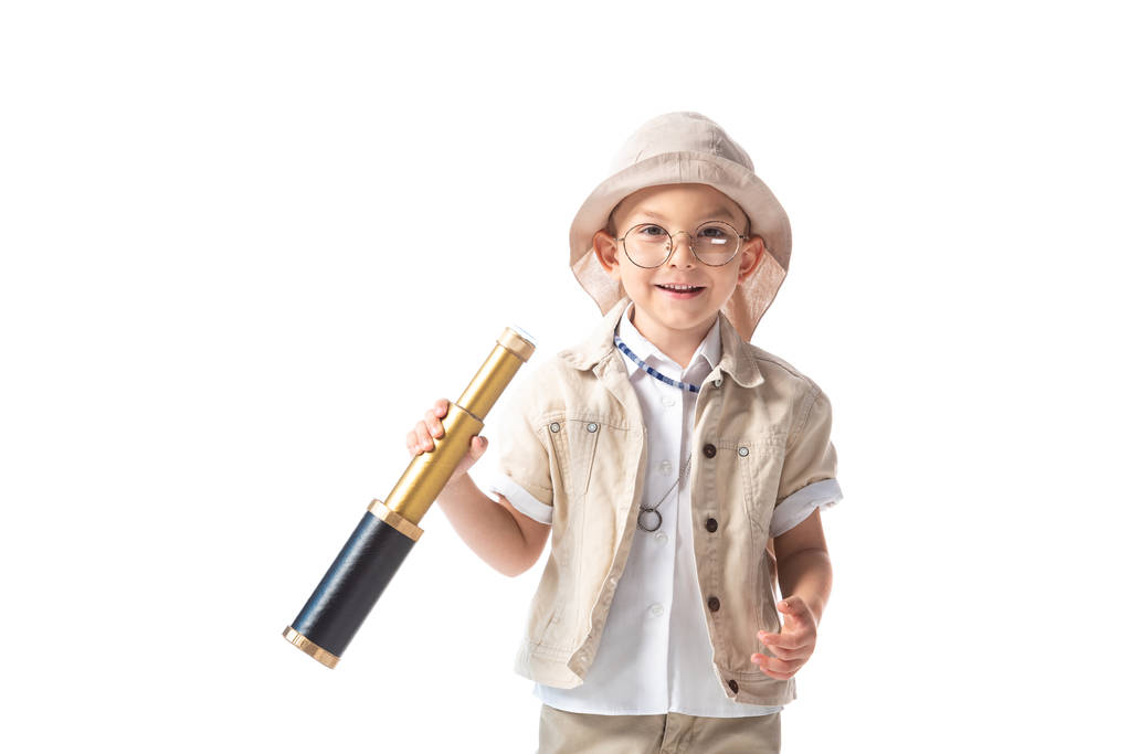 vista frontal del niño explorador sonriente en gafas y sombrero sosteniendo spyglass aislado en blanco
 - Foto, imagen