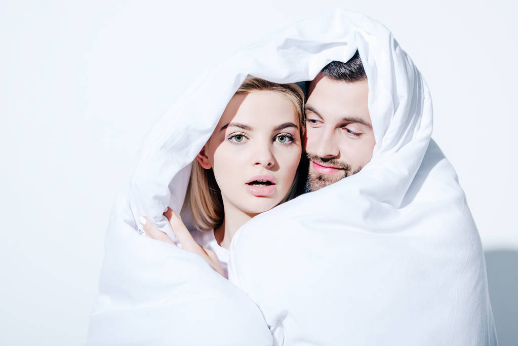 дівчина і хлопець вкриті ковдрою на білому
 - Фото, зображення
