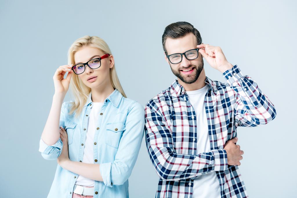 férfi és lány kiigazításáról szemüveg és nézi kamera szürke - Fotó, kép