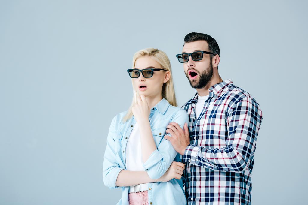 шокированные мужчина и девушка в 3D очки смотреть фильм изолирован на серый
 - Фото, изображение