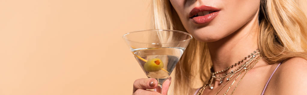 cropped view of elegant blonde woman in necklace holding cocktail isolated on beige, panoramic shot - Photo, Image