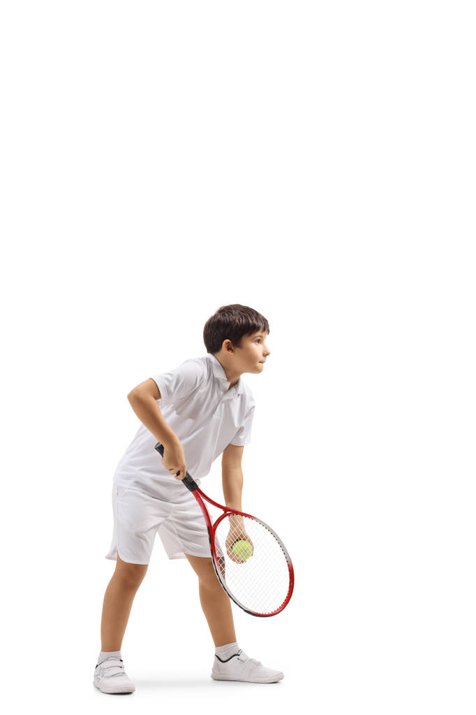 Tirador de cuerpo entero de un niño sirviendo una pelota de tenis aislado sobre fondo blanco
 - Foto, Imagen