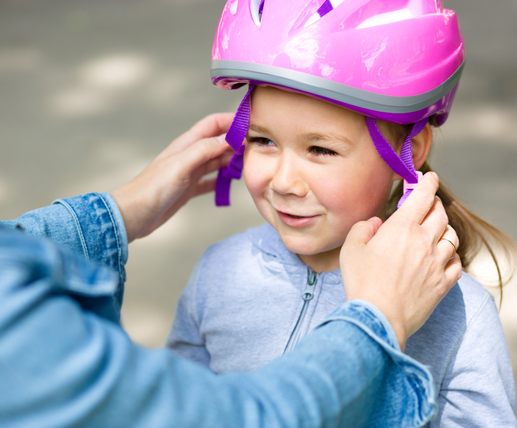 Mother is helping her daughter with safety helmet - Photo, Image