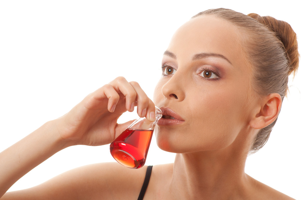 Frau trinkt eine rote Flüssigkeit - Foto, Bild