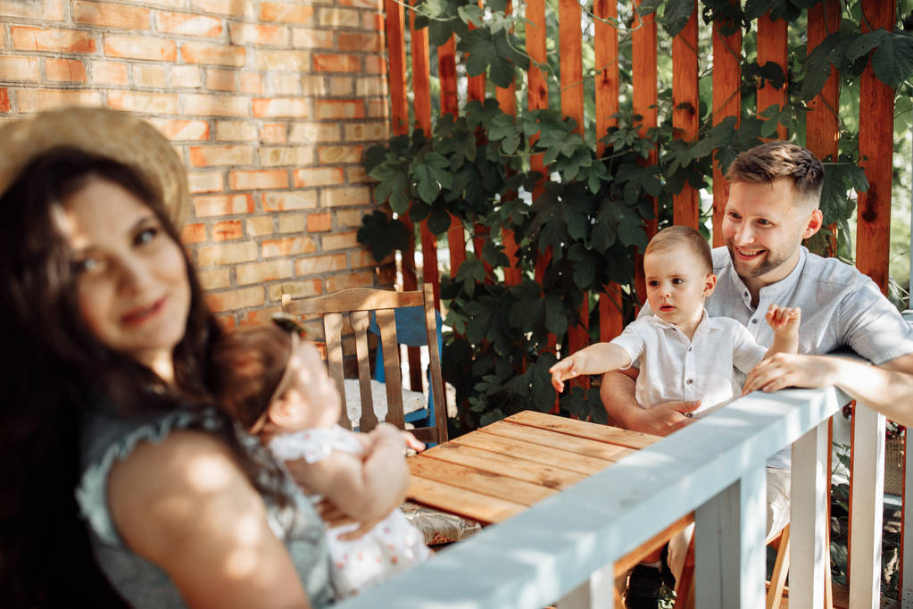 Szczęśliwa młoda rodzina w kawiarni na świeżym powietrzu  - Zdjęcie, obraz