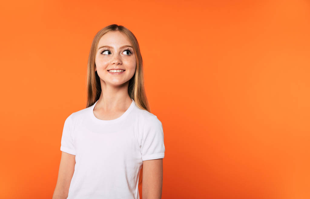 Happy lovely beautiful little blonde girl in white t-shirt isolated on colorful background - Photo, Image