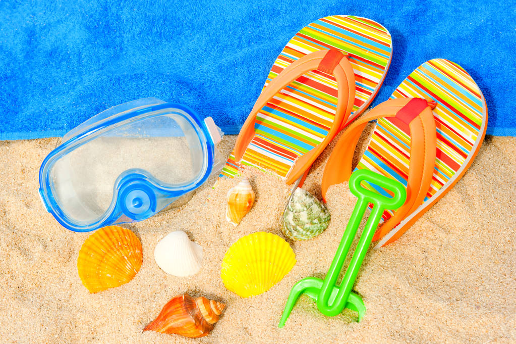 Ракушки, маска для дайвинга и сандалии на пляже
 - Фото, изображение