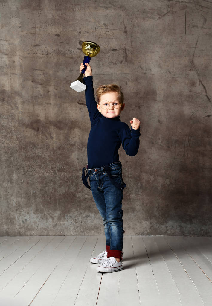 Мальчик празднует свой золотой трофей
 - Фото, изображение