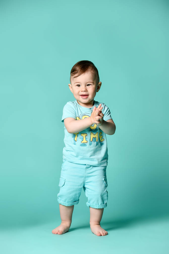 Turkuaz bir arka plan izole mavi bir yaz pamuk takım bir bebek çocuk tam uzunlukta portre. - Fotoğraf, Görsel