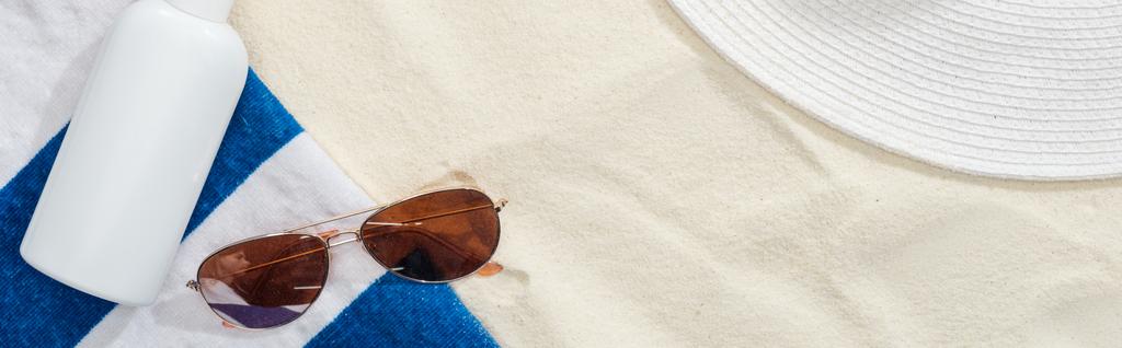 вид сверху на солнцезащитный лосьон и пляжные аксессуары на песке, панорамный снимок
 - Фото, изображение