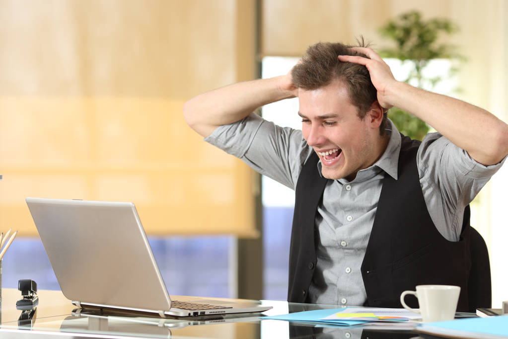 Возбужденный бизнесмен проверяет содержимое ноутбука в офисе
 - Фото, изображение