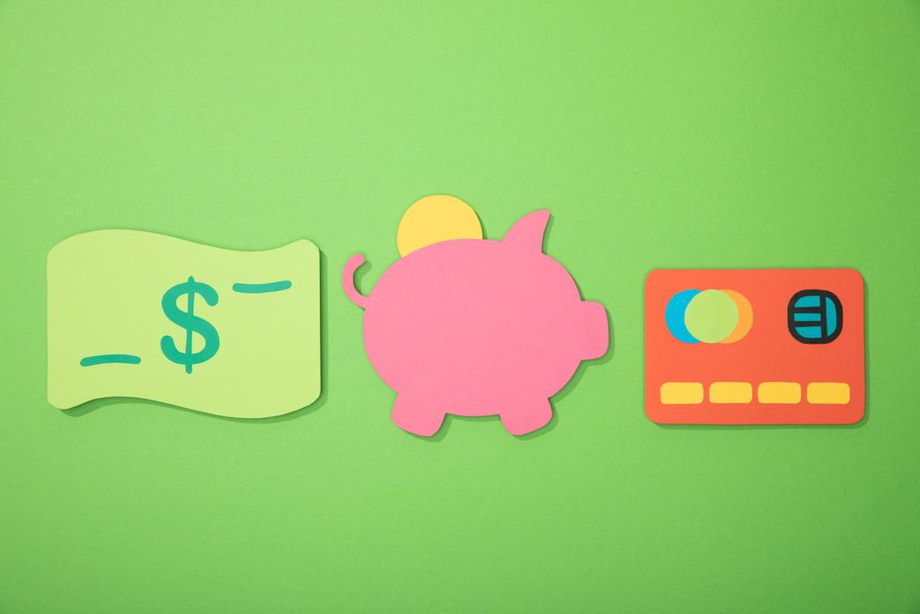 Düz yat kumbara, kredi kartı ve dolar banknot yeşil üzerinde izole - Fotoğraf, Görsel