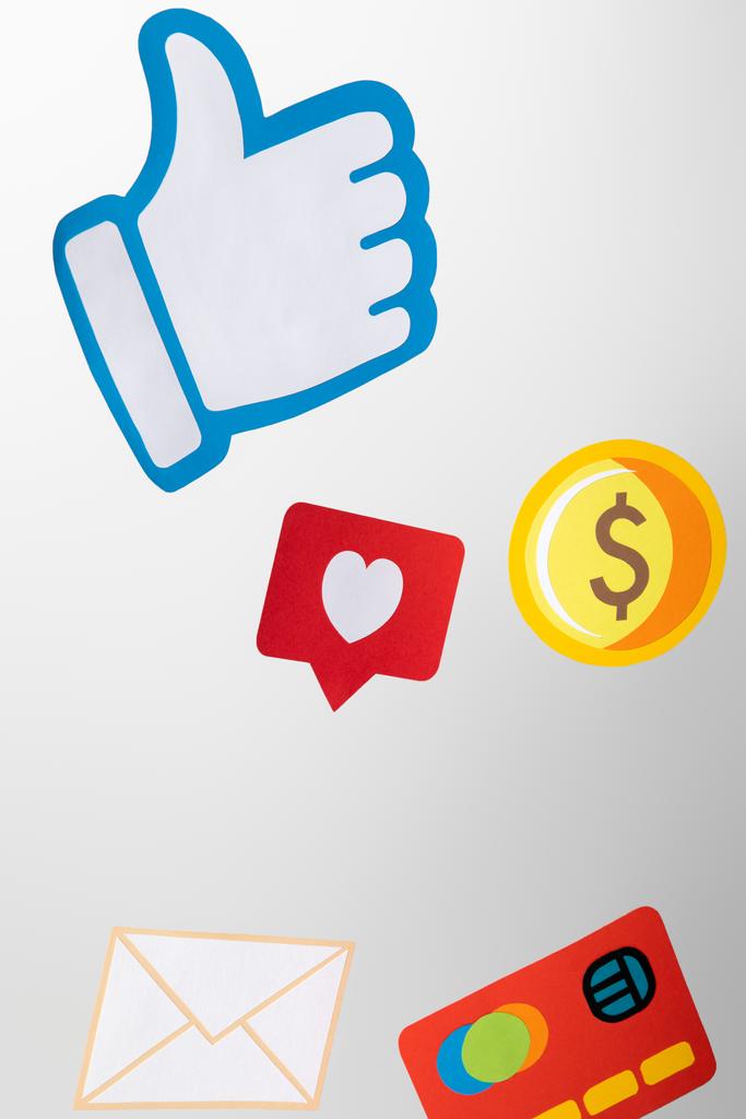 paper icons with envelope, coin, credit card, hearts and thumb up on white background - Photo, Image