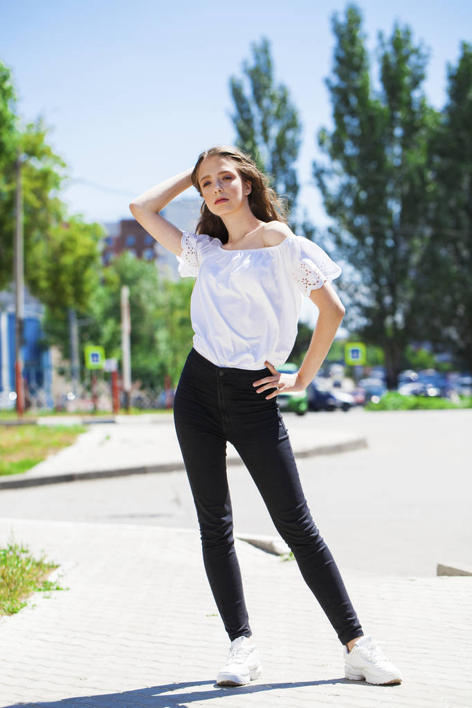 Jeune belle femme brune en jeans et chemisier blanc marche
 - Photo, image