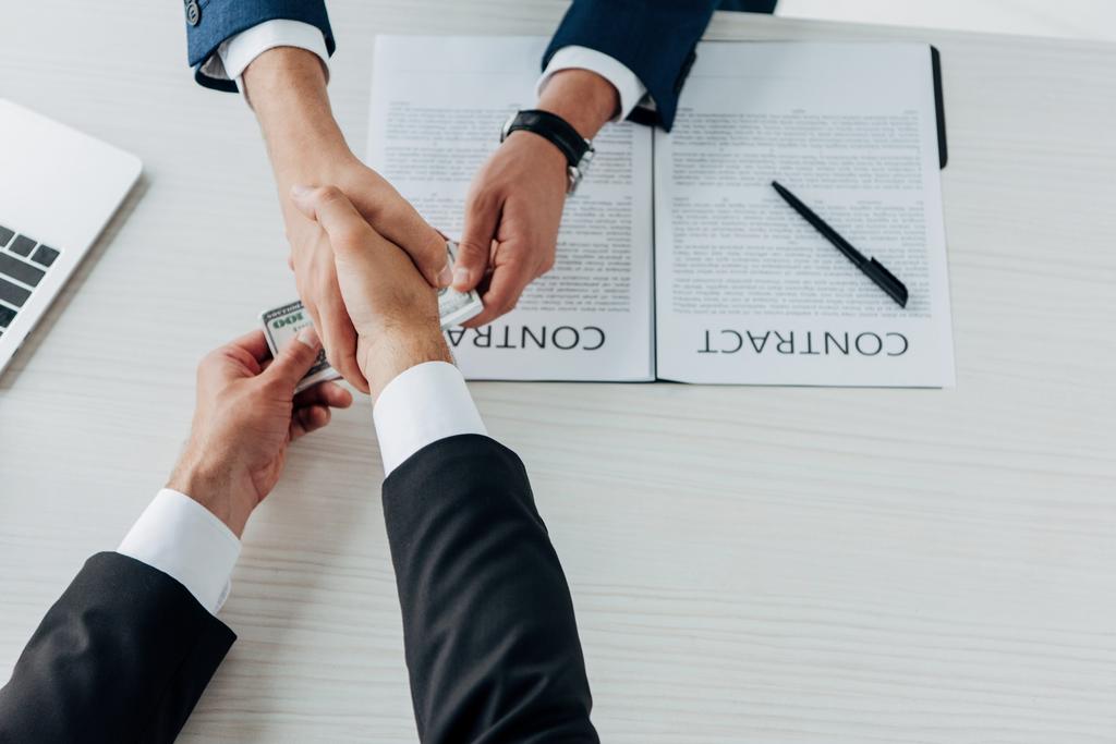 top view of man giving money and shaking hands with business partner  - Photo, Image
