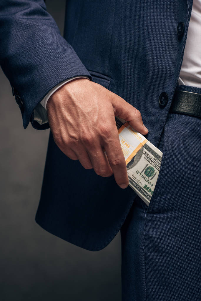 nyírt kilátás üzletember üzembe dollár bankjegyek zsebében a szürke  - Fotó, kép