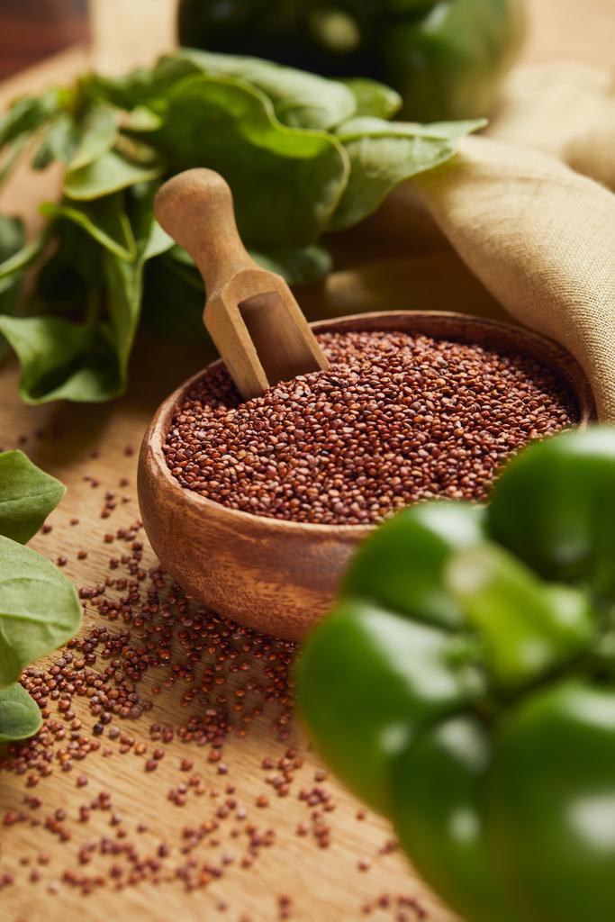foyer sélectif de poivron vert et de quinoa rouge dans un bol en bois avec spatule près de serviette beige
 - Photo, image