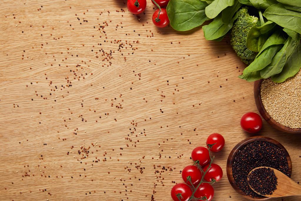 vue du dessus du quinoa blanc et noir dans des bols en bois avec cuillère près des légumes frais
 - Photo, image