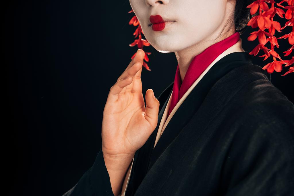 частковий вид на красиву гейшу в чорно-червоній кімоно махає рукою ізольовано на чорному
 - Фото, зображення