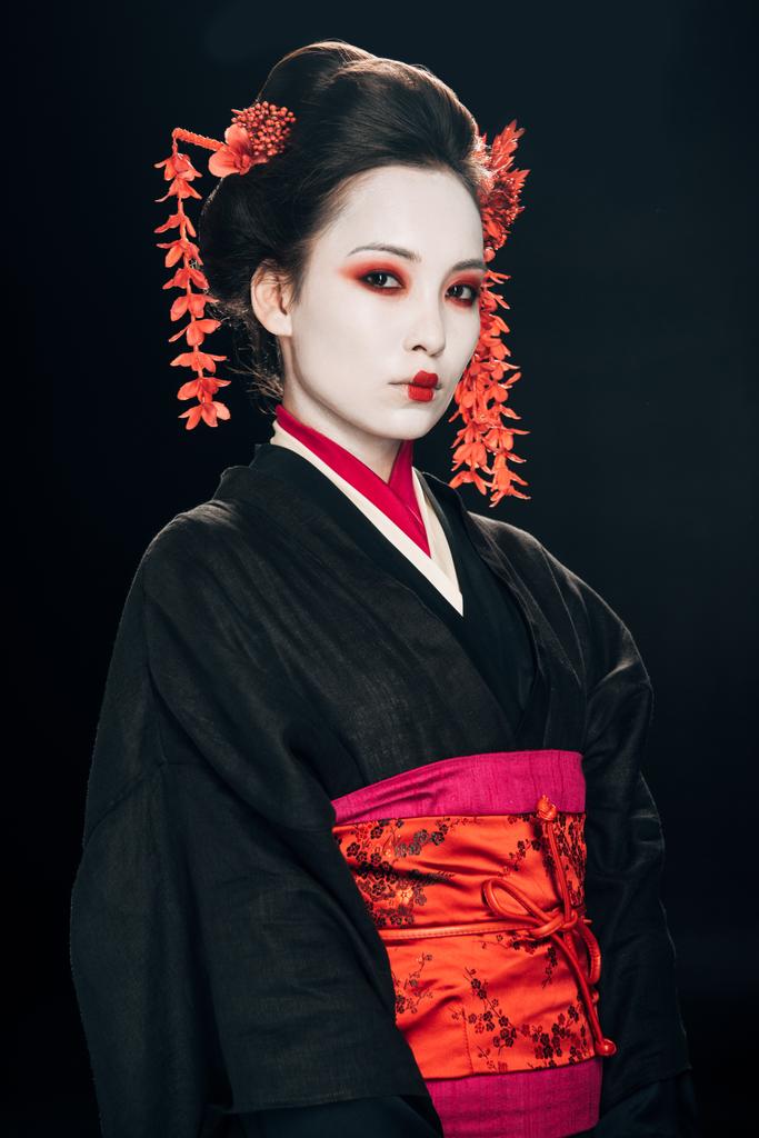 geisha in kimono nero e rosso e fiori in capelli isolati su nero
 - Foto, immagini