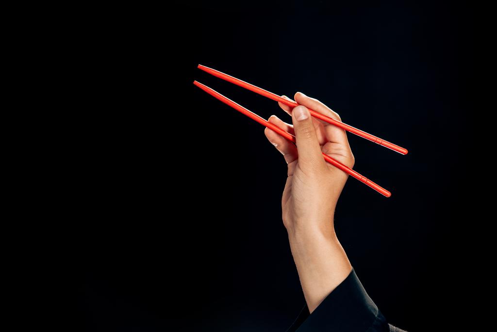 обрізаний вид жінки, що тримає палички ізольовані на чорному
 - Фото, зображення