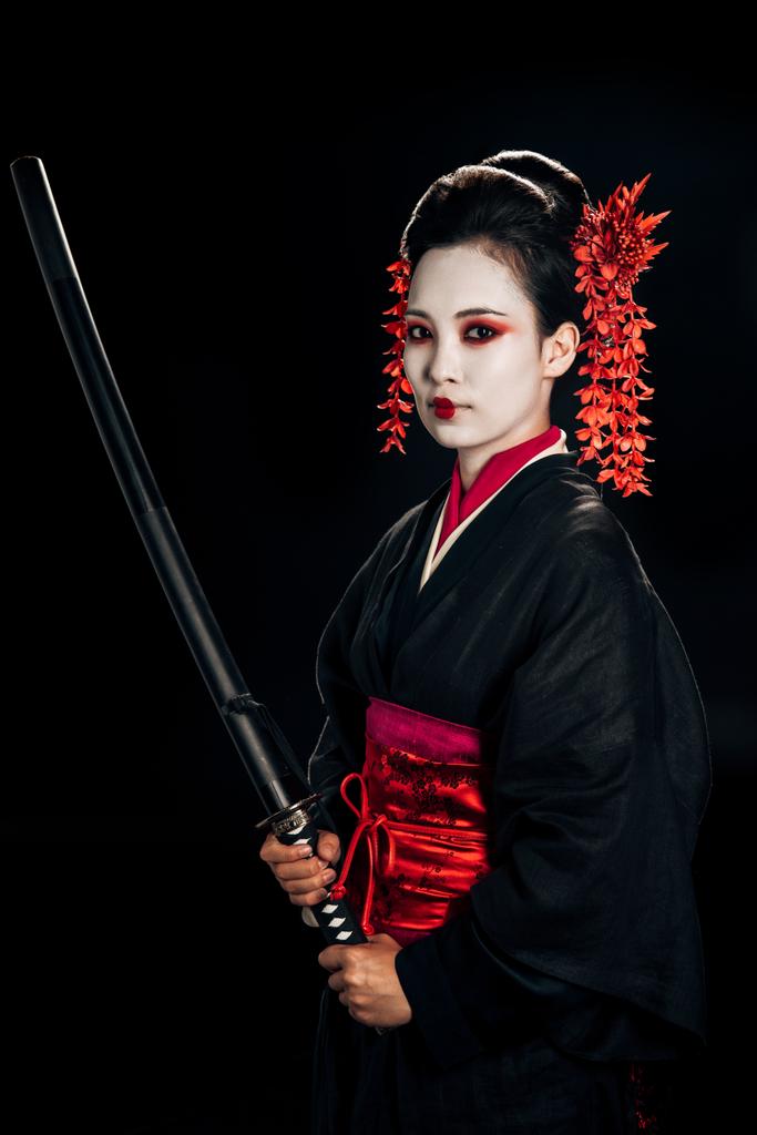 gyönyörű gésa fekete kimonó piros virágok a haj gazdaság éles Katana izolált fekete - Fotó, kép