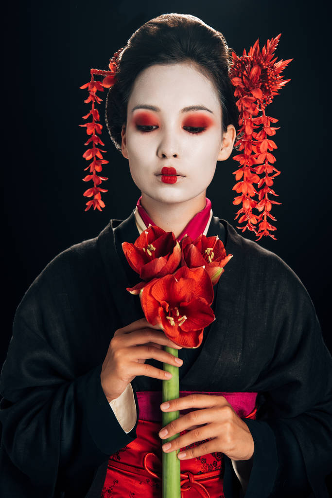 geisha joven en kimono negro con flores rojas aisladas en negro
 - Foto, imagen