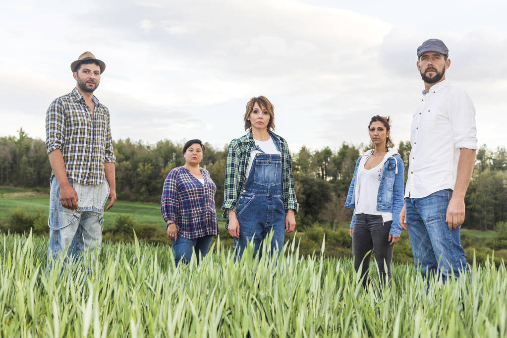 Grupo de pessoas rurais em pé no campo enquanto olha para a câmera
 - Foto, Imagem