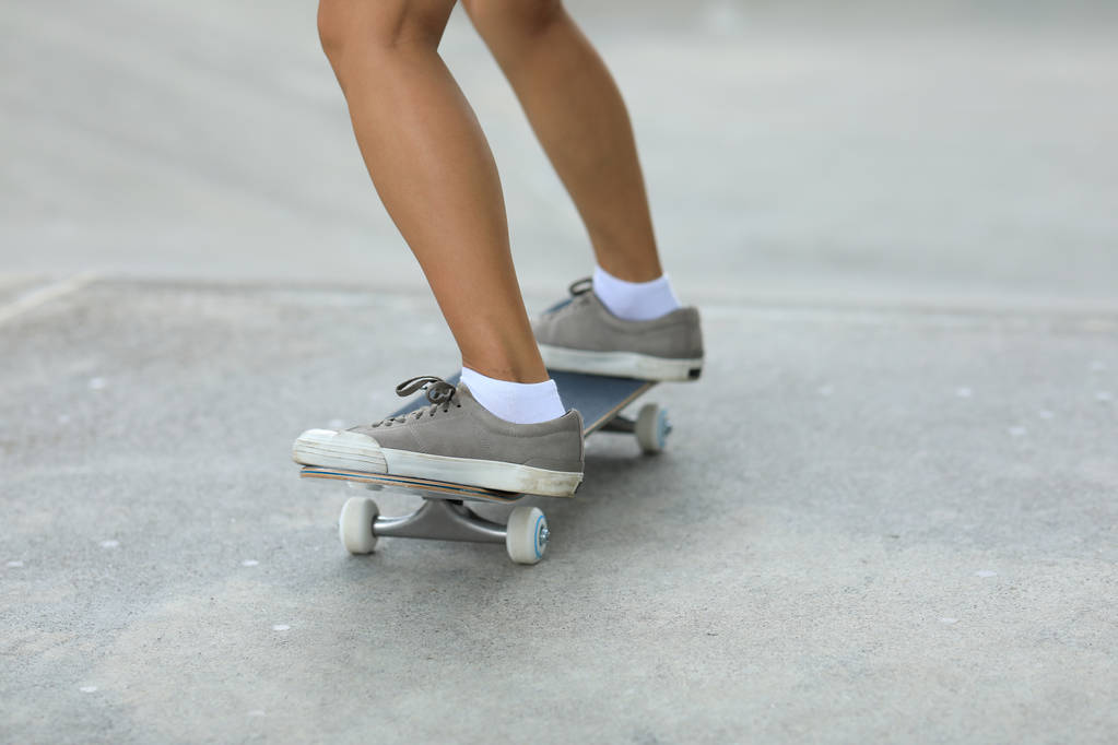 Vrouwelijke skateboarder skateboarden in het Skatepark in de stad - Foto, afbeelding