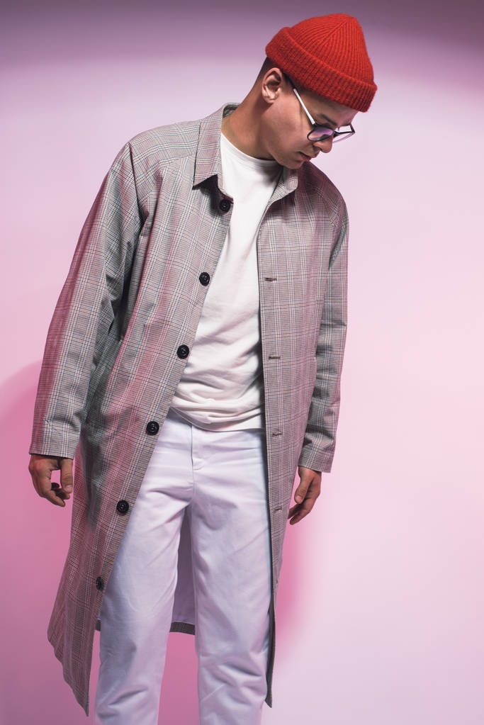 Fotografia mody młodego męskiego modelu stwarzające w modny nowoczesny miejski wygląd i emocje w Studio na białym tle i kolor żelu - Zdjęcie, obraz