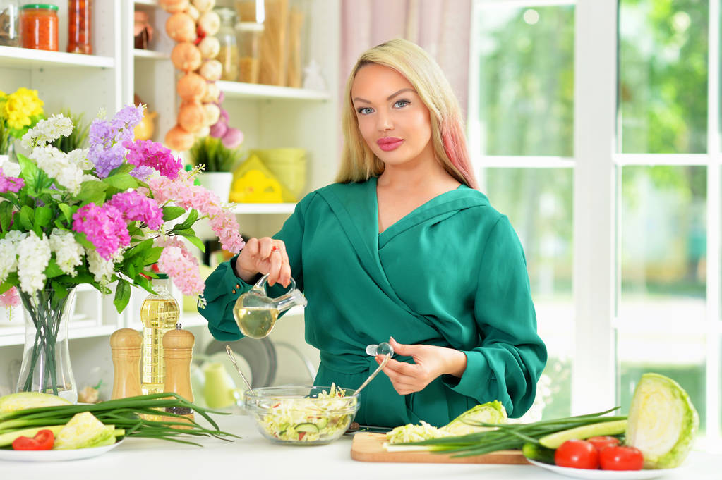 Kaunis nuori nainen ruoanlaitto keittiössä - Valokuva, kuva