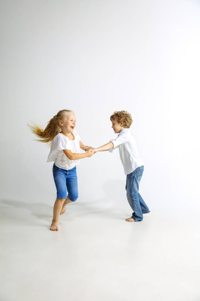 Garçon et fille jouer ensemble sur fond de studio blanc
 - Photo, image