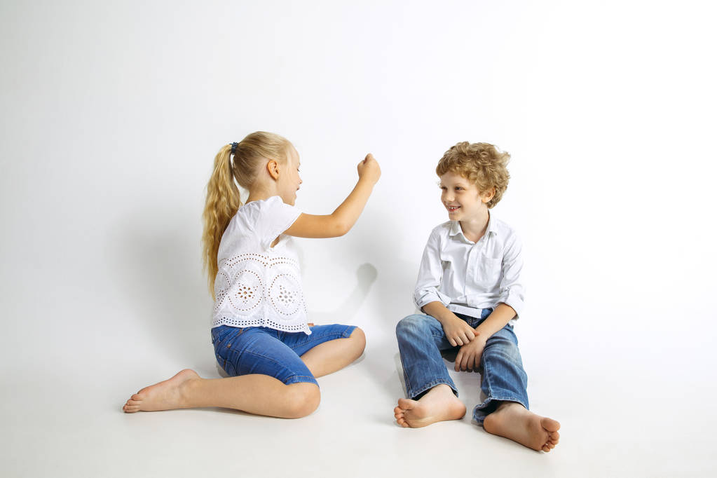 Chłopiec i dziewczyna bawią się razem na białym tle Studio - Zdjęcie, obraz