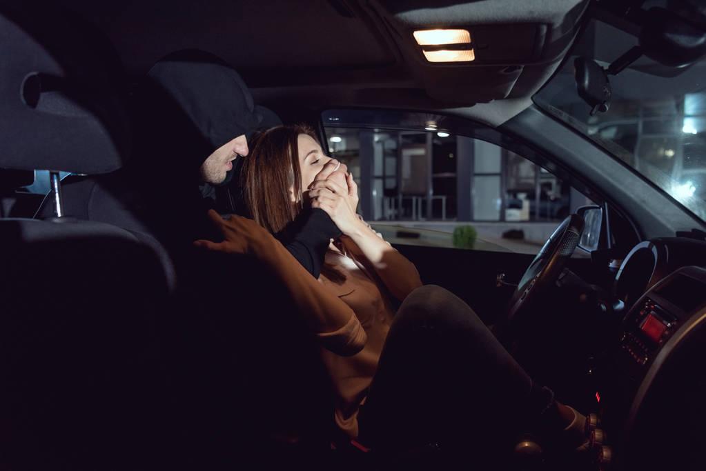 zloděj útočí na krásnou vyděšenou ženu v autě - Fotografie, Obrázek