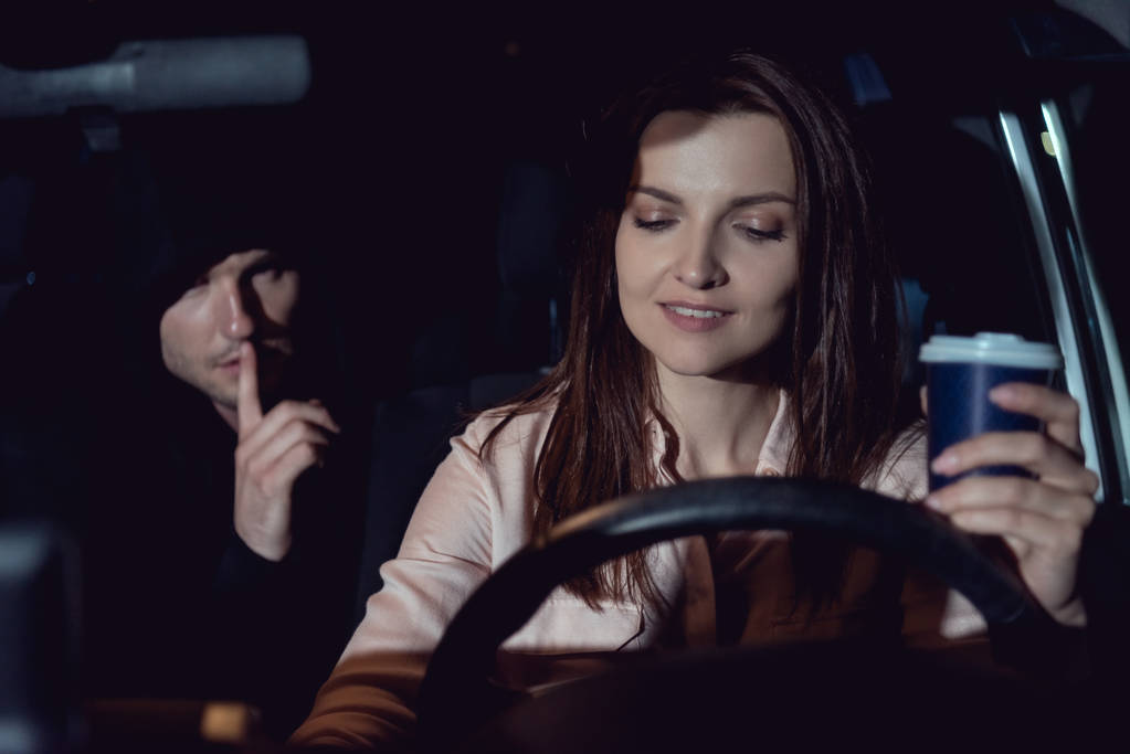Hırsız arabada güzel gülümseyen kadın yakınında sessiz jest yapıyor - Fotoğraf, Görsel