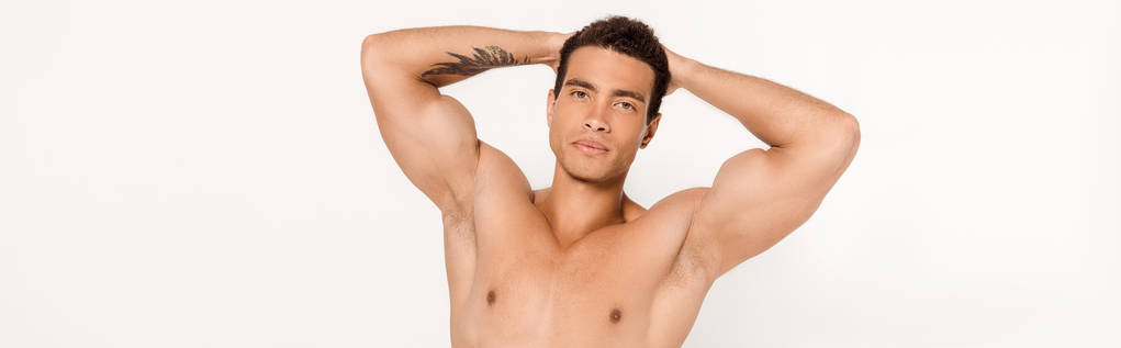 plano panorámico del hombre de raza mixta guapo con tatuaje mirando a la cámara en blanco
  - Foto, imagen
