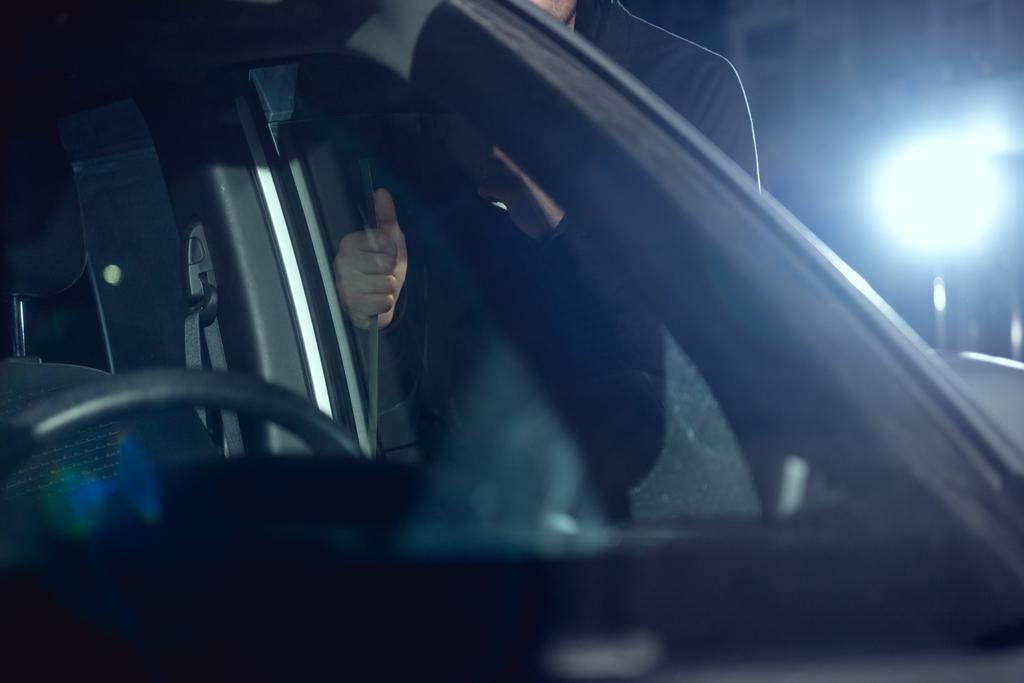 обрізаний вид на злодія, який інтригує машину з кронштейном
 - Фото, зображення