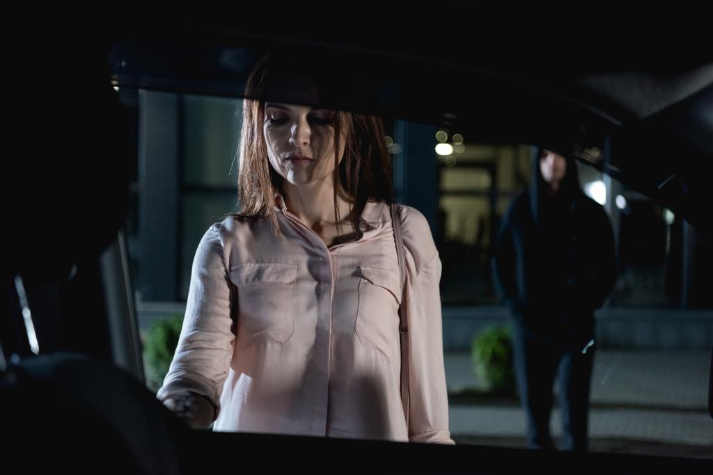 thief following beautiful woman opening car at nighttime - Photo, Image