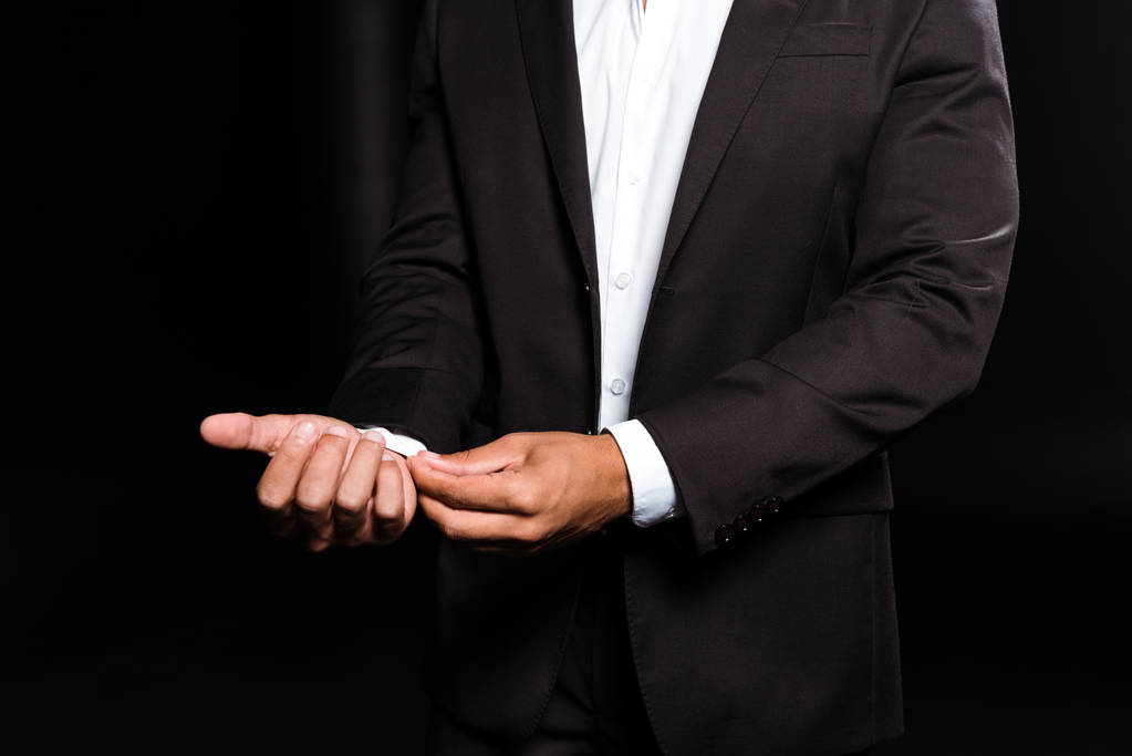 vue recadrée de mixte homme toucher chemise blanche isolé sur noir
  - Photo, image