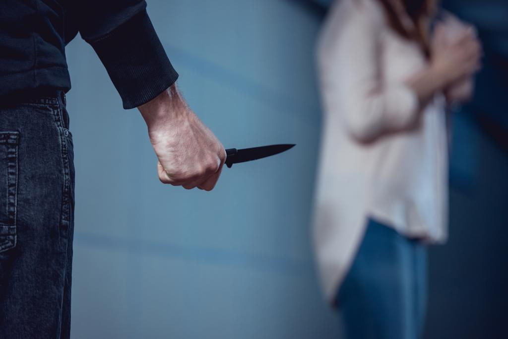 foco seletivo de ladrão com faca em pé perto de mulher
 - Foto, Imagem