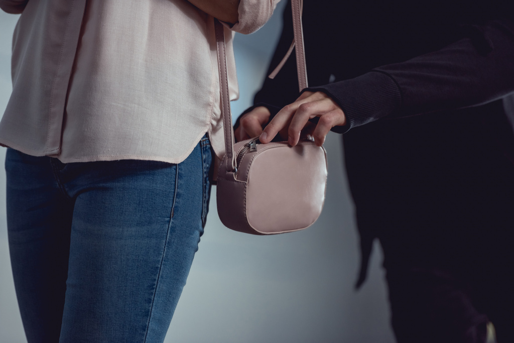 Περικομμένη άποψη του κλέφτη κλέβοντας χρήματα από την τσάντα της γυναίκας - Φωτογραφία, εικόνα