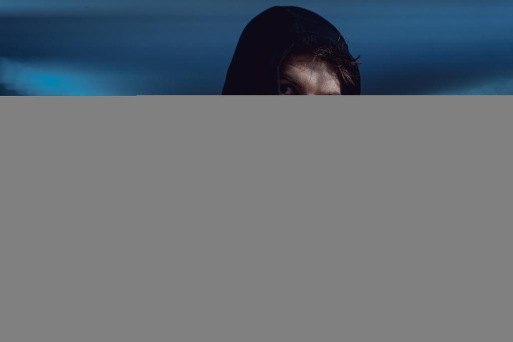 Hübscher Dieb mit schwarzem Kapuzenpulli in Unterführung im Fokus - Foto, Bild