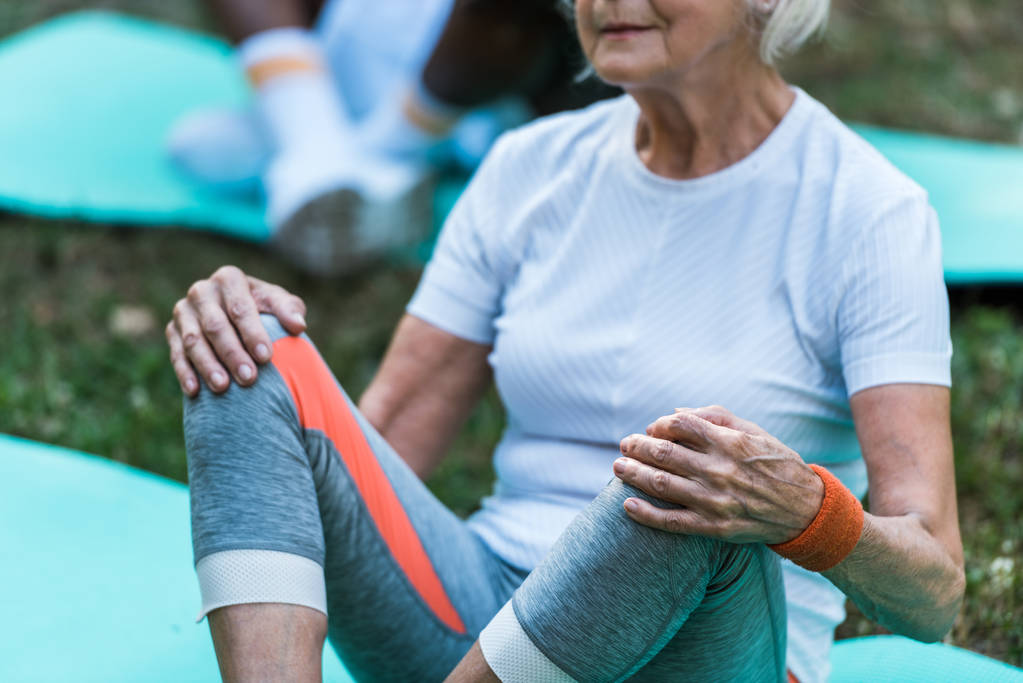Ausgeschnittene Ansicht einer Seniorin in Sportbekleidung auf Fitnessmatte - Foto, Bild