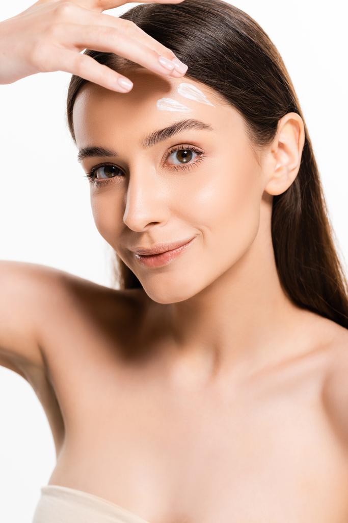 hermosa joven feliz mujer con la piel perfecta aplicación de crema cosmética en la cara aislada en blanco
 - Foto, Imagen
